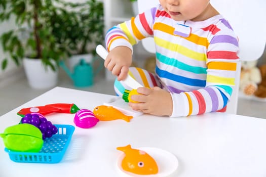 Child plays kitchen and food toys. Selective focus. Kid.