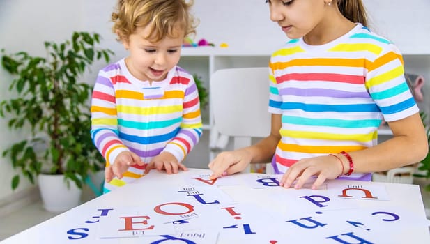 The child learns English letters. Selective focus. Kid.