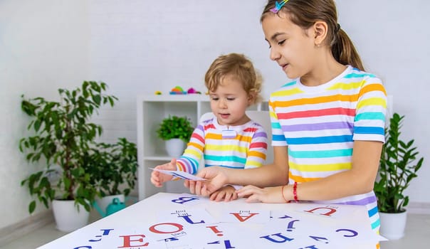 The child learns English letters. Selective focus. Kid.