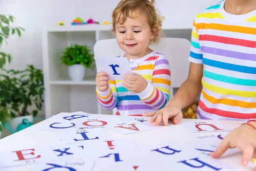 The child learns English letters. Selective focus. Kid.