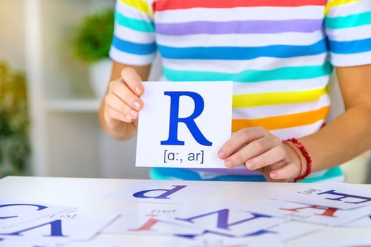 The child learns English letters. Selective focus. Kid.