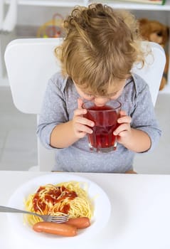 The child eats spaghetti lunch. Selective focus. Food.