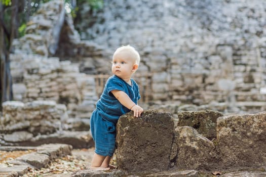 Baby tourist at Coba, Mexico. Ancient mayan city in Mexico. Coba is an archaeological area and a famous landmark of Yucatan Peninsula. Cloudy sky over a pyramid in Mexico.