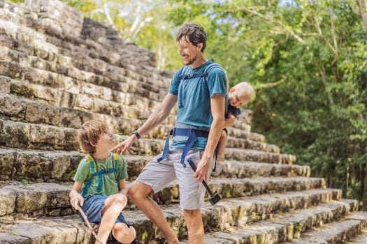 Dad with two sons tourists at Coba, Mexico. Ancient mayan city in Mexico. Coba is an archaeological area and a famous landmark of Yucatan Peninsula. Cloudy sky over a pyramid in Mexico.