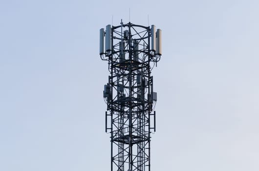 A very tall tower with a collection of cell phones on top of it.