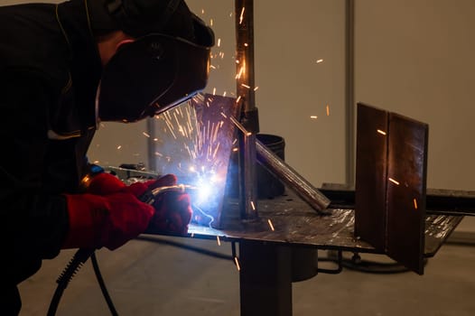 Competitions among welders. A man in a protective mask is welding