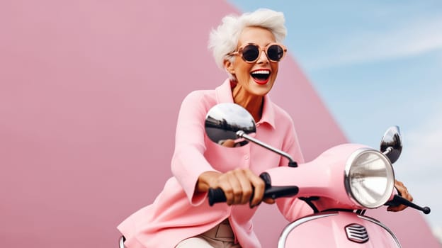 Cheerful happy senior woman riding pink scooter, stylish elderly female driver driving moped enjoying summer vacation, road trip