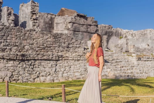 Woman tourist enjoying the view Pre-Columbian Mayan walled city of Tulum, Quintana Roo, Mexico, North America, Tulum, Mexico. El Castillo - castle the Mayan city of Tulum main temple.