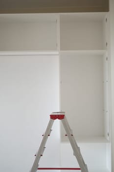 Metal ladder standing in empty room, renovation and improvement concept