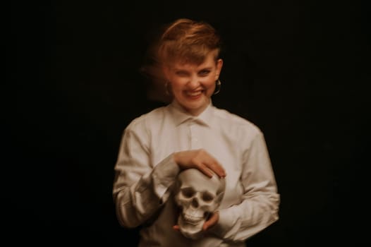 psychopath with schizophrenia and mental disorders. Portrait of a girl with a skull in hands on a dark background