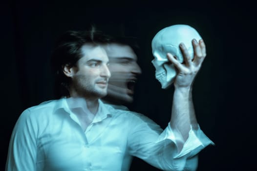 abstract blurry portrait of a psychopathic man with mental disorders with a human skull in his hand on a dark background