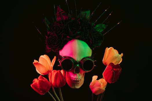 human skull in steampunk glasses and a crown of black roses in flowers with colored neon light on a dark background. Concept of celebrating a traditional Mexican holiday of Dia De Los Muertos