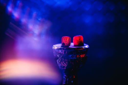 charcoal for Shisha on the bowl of hot red on a blue background for traditional East holiday in Asia