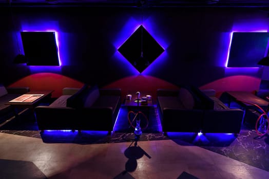 dark interior hookah with led light with sofas and tables
