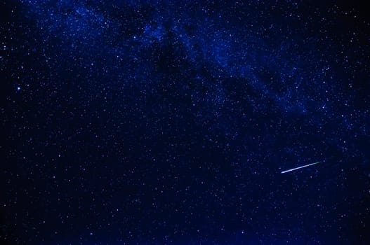 shooting star on the background of blue dark night starry sky