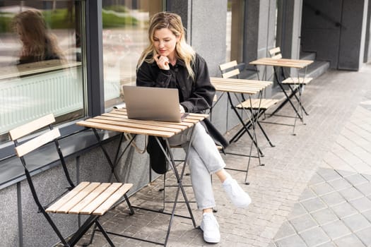 Young woman working at a remote job in a cafe. High quality photo