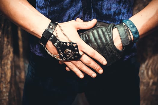 male hands in gloves with skull and chains, fetish
