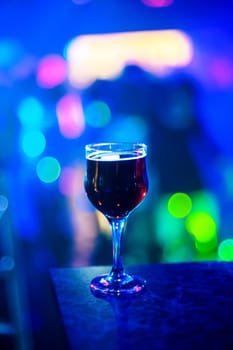 glass of wine at a party on blurred blue background