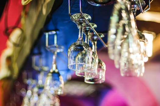empty glasses hanging above the bar closeup