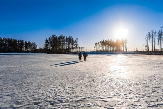 anglers under Sunny skies in winter on the lake