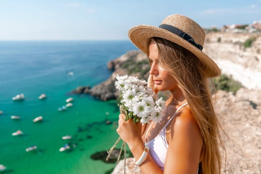 Woman travel sea. Happy woman in a beautiful location poses on a cliff high above the sea, with emerald waters and yachts in the background, while sharing her travel experiences.