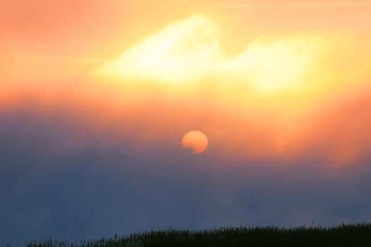 the sunrise in the early morning through the mist