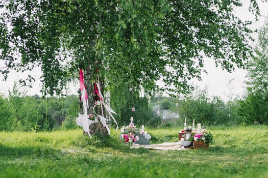 wedding decor from the flowers and decorations with a swing under the trees outdoors in summer