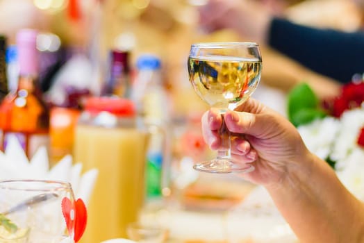glass of white wine in hand at the feast, making a toast