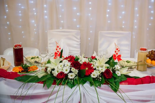 table is decorated with artificial flowers, food and drinks in the restaurant