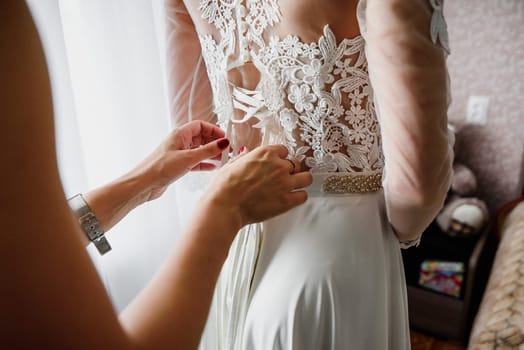 bridesmaid tying a ribbon on elegant, possible wedding white bridesmaid dress