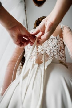 white wedding dress with lace and ribbons on the bride wears a friend