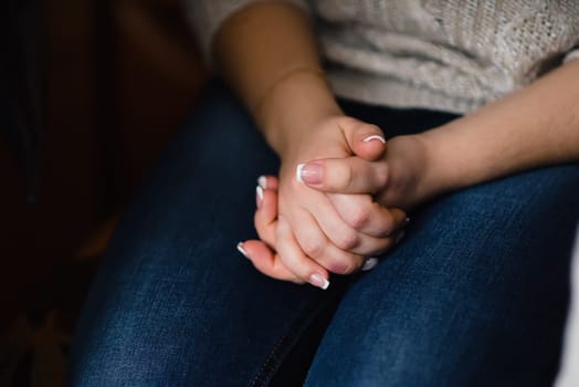 white French manicure on woman's hands folded