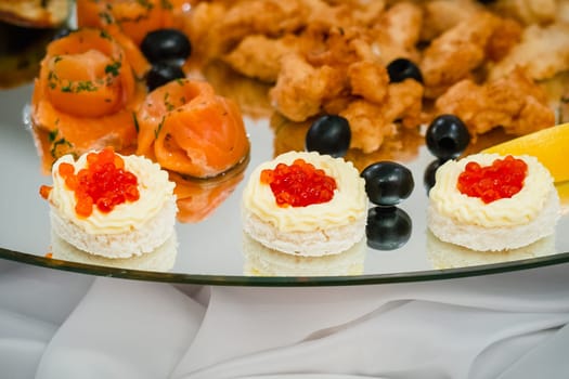 caviar fish, and pieces of red fish in the restaurant on a plate closeup
