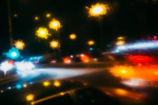 blurred background-night street with lights in the side and raindrops on the glass