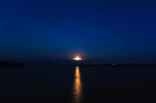 night landscape with moon and stars on a background of sky and river with reflection
