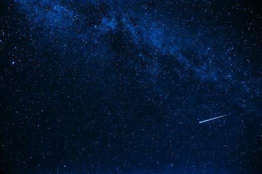 shooting star in background a starry blue sky at night