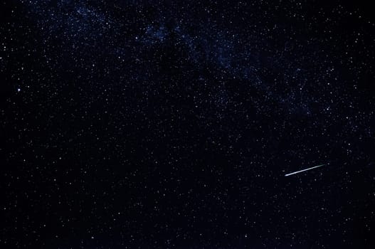 dark starry sky with falling star and the milky way on a black background