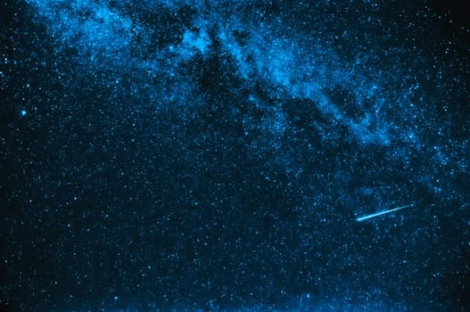 falling star on a background of blue sky with the milky way