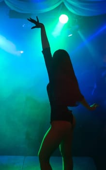 silhouette of a go-go dancer girl on stage in a nightclub