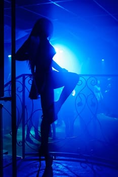 slim sexy flexible girl is dancing in night club on stage silhouette