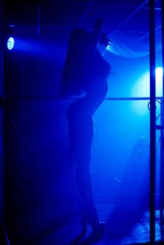 young girl with slender thin sexy body posing on the dance floor in a nightclub