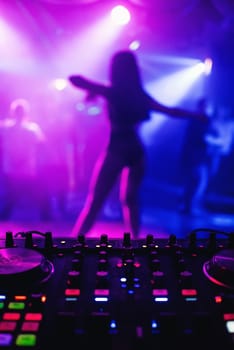 night club with a DJ mixer and a blurred silhouette of a female dancer with a colorful background