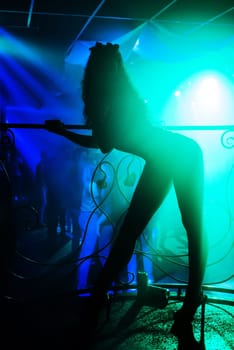 sexy slender girl on the dance floor of a night club on the stage of the beautifully curved silhouette