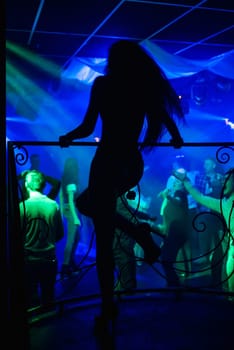 silhouette of a go-go dancer girl on stage in a nightclub