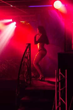 young girl with sexy slender body dancing on the stage dance floor night club