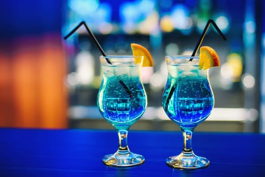 blue Martini cocktail in glass with orange on the bar delicious and colorful party guests with alcohol