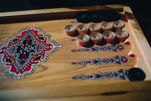 Board for gambling at backgammon with patterns and wooden checkers black and white