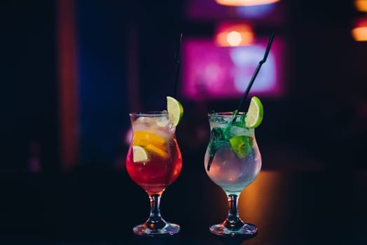 two glass of Mojito cocktail with ice, lime and mint with tubes on the bar at the party