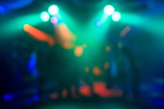 blurred abstract background of colored lights in night club with bokeh out focus and bright spots