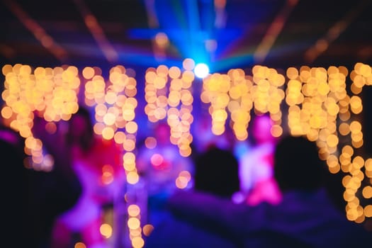 blurred background in nightclub with bright multi-colored bokeh